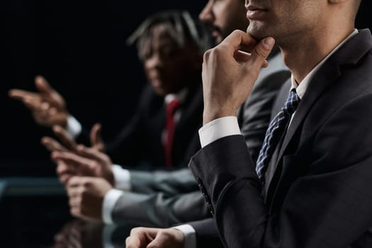 Pensive employee in the office on the background of his colleagues.