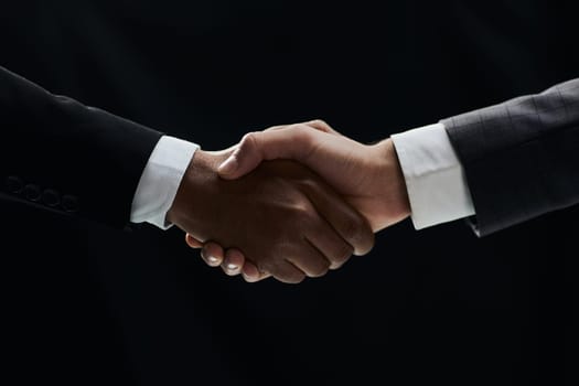 African businessman's hand shaking white businessman's hand