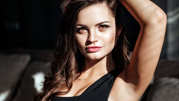 close-up of the seductive face of the brunette with beautiful makeup and sexy lips. luxurious hairstyle and flirtatious look.