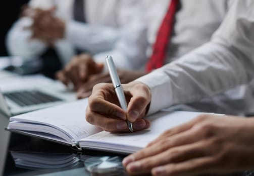 Businessman writes with a pen in diary, business and education concept. Close up