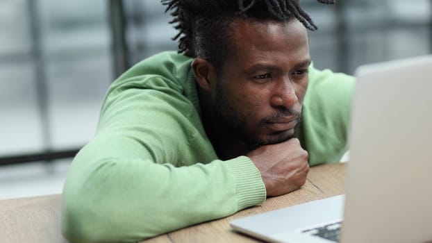 Business man in casual clothes thinking behind a laptop