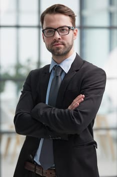portrait of confident businessman with arms crossed in office