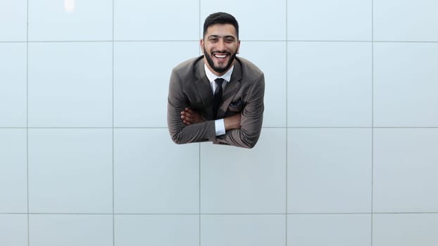 Handsome smiling business man in a suit standing with his arms crossed. View from above