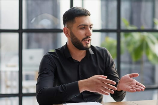 Positive businessman talking on headset at a computer