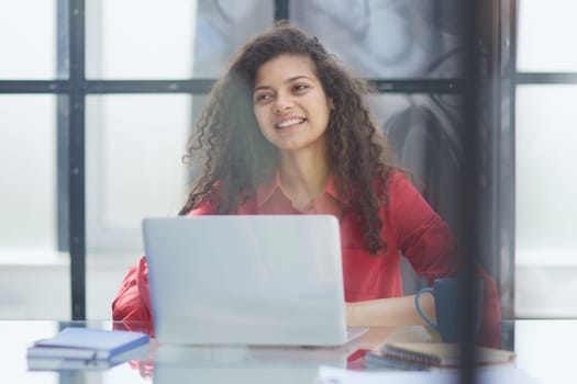 Portrait of Young Successful Caucasian Businesswoman Sitting at Desk Working on Laptop Computer in City Office