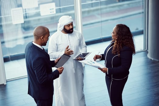 Communication is vital in the pursuit of success. High angle shot of a group of diverse business colleagues working together in their corporate office