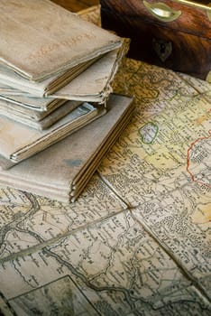 Ancient topographic maps on a table, with an old wooden box