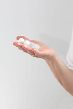 Hand Holds Two Glass Bottles With Lash Lift Lotion For Eyelash Lamination Treatment Procedure. Curling, Staining, Extension Procedures For Lashes. Vertical Plane, Closeup.