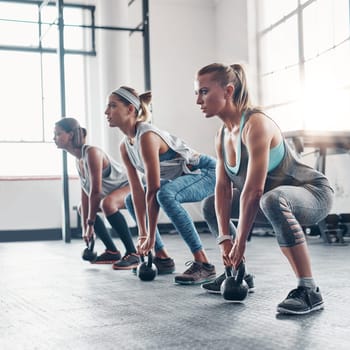 Group, exercise and women training, kettlebell and workout goal with wellness, healthy lifestyle and sports. Female athletes, girls and friends with gym equipment, balance and stretching for cardio.