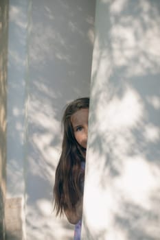 Beautiful girl peeking out from behind the column. High quality photo