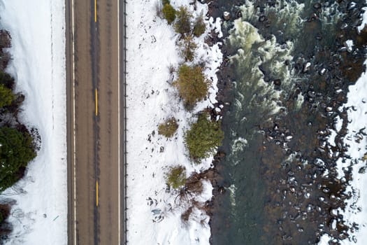 top down view of a snow landscape including a road next to a river