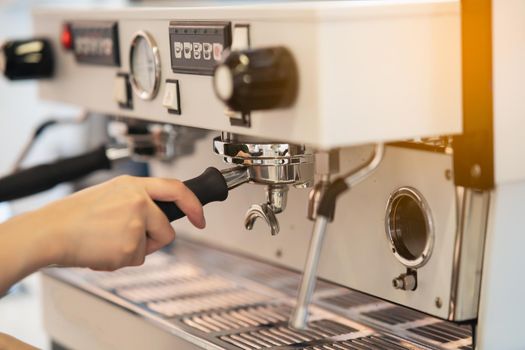 women barista making coffee in a coffee machine, coffee making concept