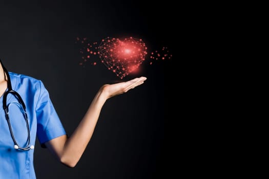 A doctor holds a glowing red heart in her hand. A nurse girl, a cardiologist shows the care for the patient, suggests remembering the need to maintain the health of the cardiovascular system.