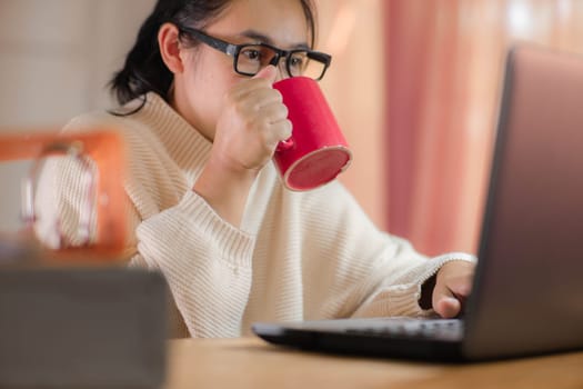 businesswoman drinking red cup of coffee at work.