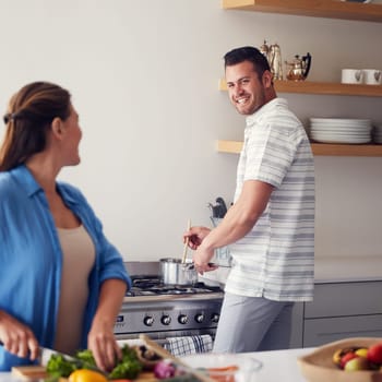 Cooking together is how we learnt what foods we love. a married couple making food together in the kitchen at home