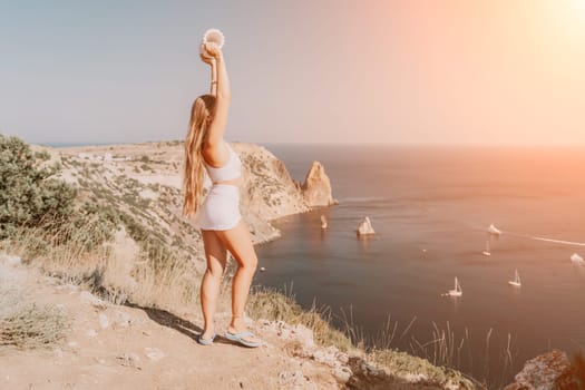 Woman travel sea. Young Happy woman in a long red dress posing on a beach near the sea on background of volcanic rocks, like in Iceland, sharing travel adventure journey