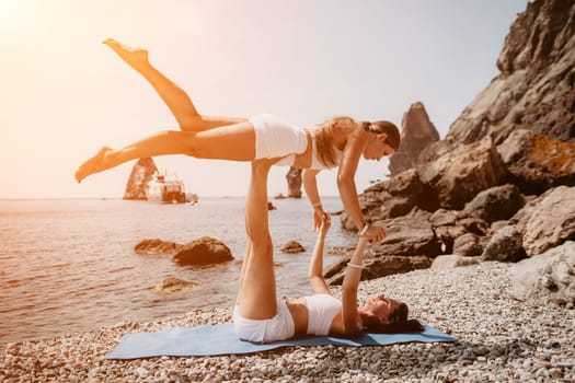 Woman sea yoga. Back view of free calm happy satisfied woman with long hair standing on top rock with yoga position against of sky by the sea. Healthy lifestyle outdoors in nature, fitness concept.