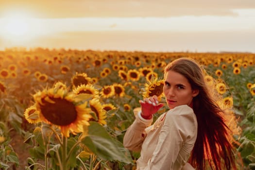 Woman in the sunflowers field. Summer time. Young beautiful woman standing in sunflower field.