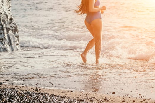 Running woman. Female runner jogging during the sunrise on beach. Woman Runner feet running on the beach at sunrise. woman fitness sunrise jog workout wellness concept.