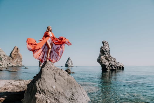 Woman travel sea. Happy tourist taking picture outdoors for memories. Woman traveler looks at the edge of the cliff on the sea bay of mountains, sharing travel adventure journey.