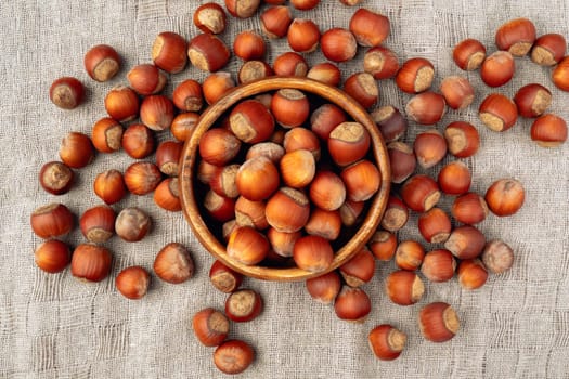 Hazelnuts in wooden bowl on a linen napkin background. Organic hazelnut. Flat lay