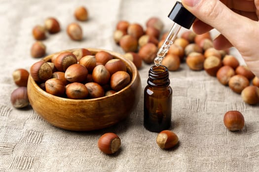 Hazelnut oil for Cosmetic or beauty care on a linen napkin natural background.