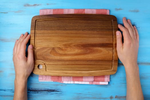 Cutting board on a wooden kitchen table. Free space for your decoration