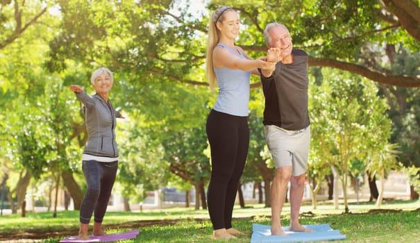 Yoga, wellness and an old couple with their personal trainer in a park for a health or active lifestyle. Exercise, fitness or zen and senior people outdoor for a workout with their pilates coach.