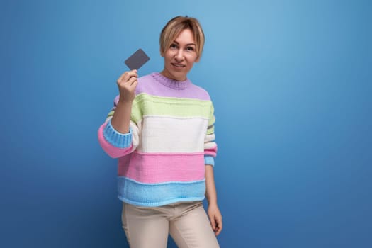 girl holding a credit card with a mockup on a blue background.