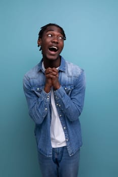 portrait of a young american man with dreadlocks in a denim jacket hoping and praying.