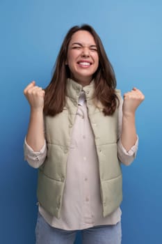 optimist 30s brunette young woman in casual look rejoices in victory.