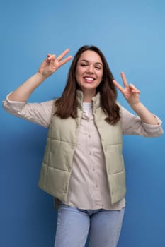 friendly cute brunette young woman in vest and shirt.