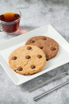 Chocolate chip cookies with tea on the stone table