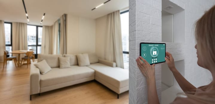 Controlling home with a digital touch screen panel installed on the wall in the living room. Concept of a smart home and mobile application for managing smart devices at home