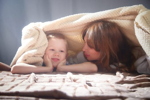 Woman with boy. Mom with son on a white background. Family portrait with mother and boy having fun together