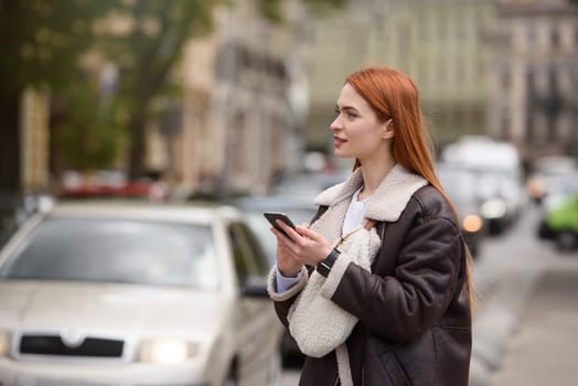 happy woman communicates with friends via video link outdoors on an old town street.