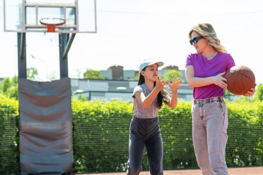 Mother and daughter playing basketball