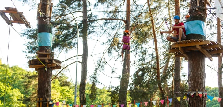 Smiling little girl on the playground, climbing rope net.