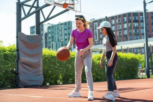 Mother and daughter playing basketball