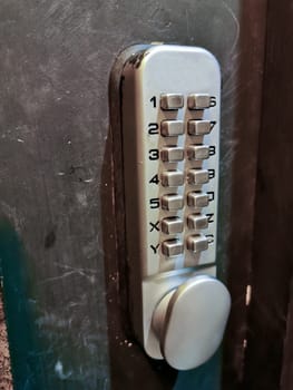 Grey silver number keypads security door locker on black door