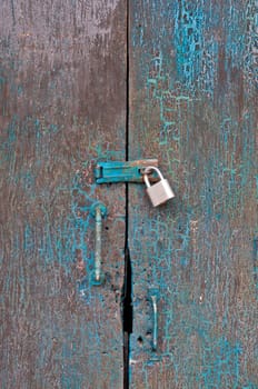 Old dark cyan wooden closed door of a traditional house in Asia with golden lock