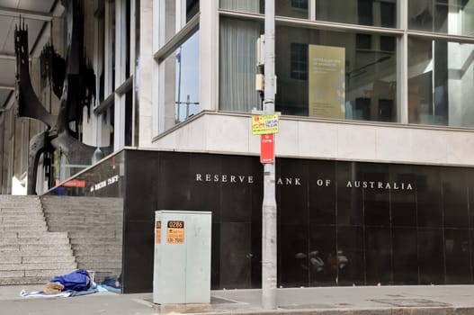 SYDNEY, AUSTRALIA - APRIL 14, 2019: Reserve Bank of Australia name on black granite wall in Sydney Australia with a homeless man sleeps nearby