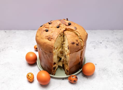 Easter Panettone Italian Cake On Table With Colored Easter Hen Eggs. Fruitcake, Sweet Bread, Originally From Milan, Italy. Pastry Dessert. Pasqua Christian Festival, Cultural Holiday. Horizontal Plane