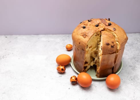 Easter Panettone Italian Cake On Table With Colored Easter Hen Eggs. Fruitcake, Sweet Bread, Originally From Milan, Italy. Pastry Dessert. Pasqua Christian Cultural Holiday. Copyspace, Horizontal