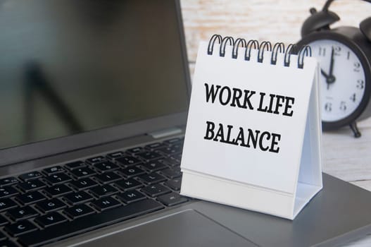 Work life balance text on table notepad with laptop background. Working culture concept.