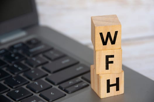 WFH letter on woooden cube. Work From Home concept.