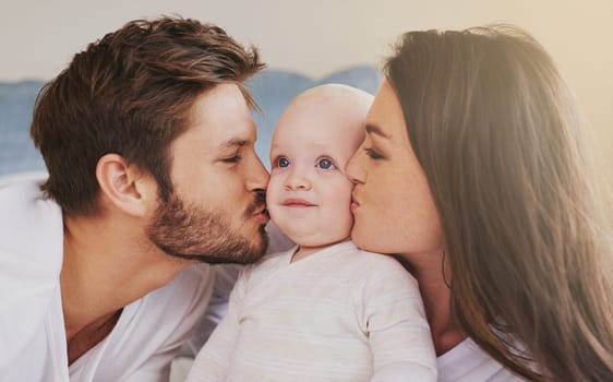 Happy father, mother and kiss baby on cheek for love, care and quality time to relax together in family home. Mom, dad and kissing cute newborn kid for happiness, loving support or infant development.