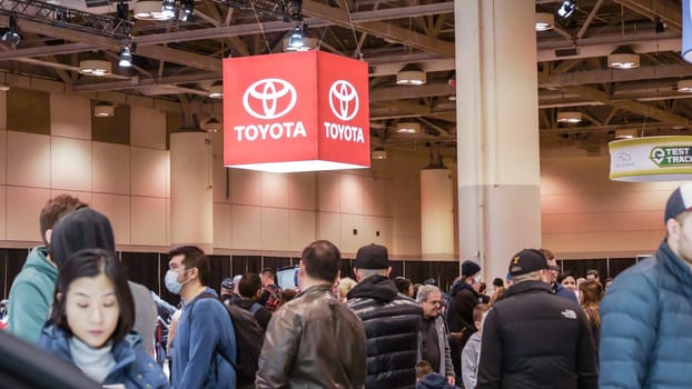 Crowds looking at new car models at Auto show. New car on display. National Canadian Auto Show with many car brands. Toronto ON Canada Feb 19, 2023