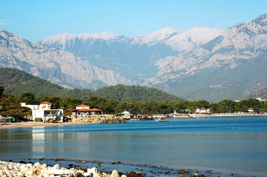 Nice view of Kemer beach with sand and mountains. Beautiful harbor near the sandy beach.