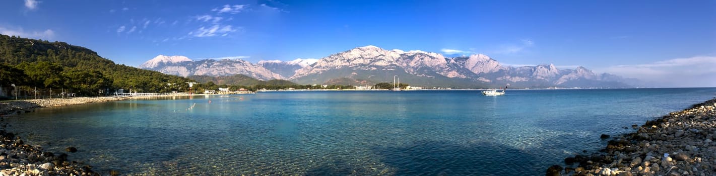 Kemer Antalia nice view of the sea. Beach Kemer Antalia with sand and mountains, the sea with the ship. Beautiful harbor near the sandy beach.